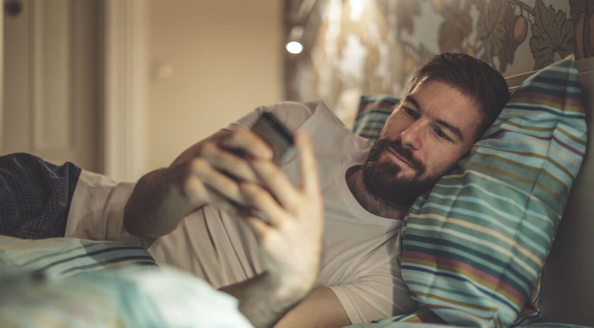 Junger Mann informiert sich über Android 8 am Smartphone.