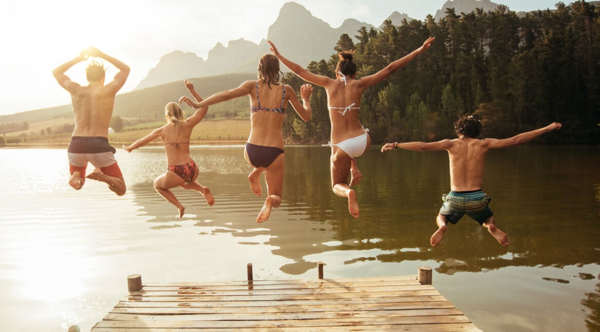 Gruppe am See springt ins Wasser