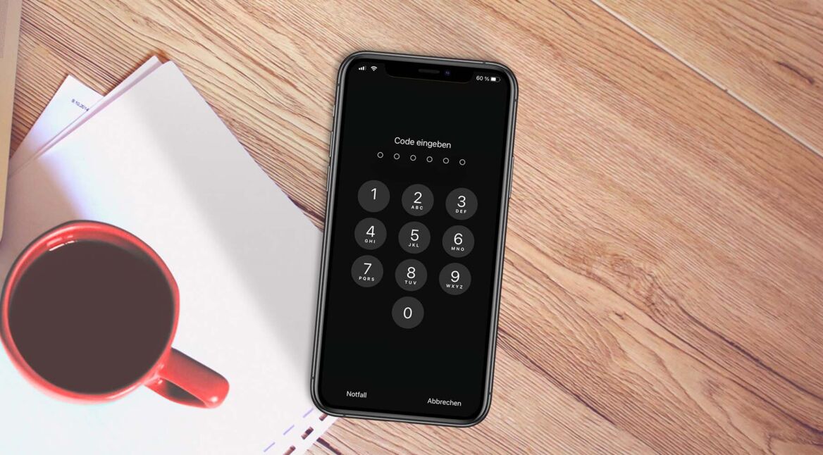 iPhone mit "Code eingeben"-Screen auf einem Schreibtisch