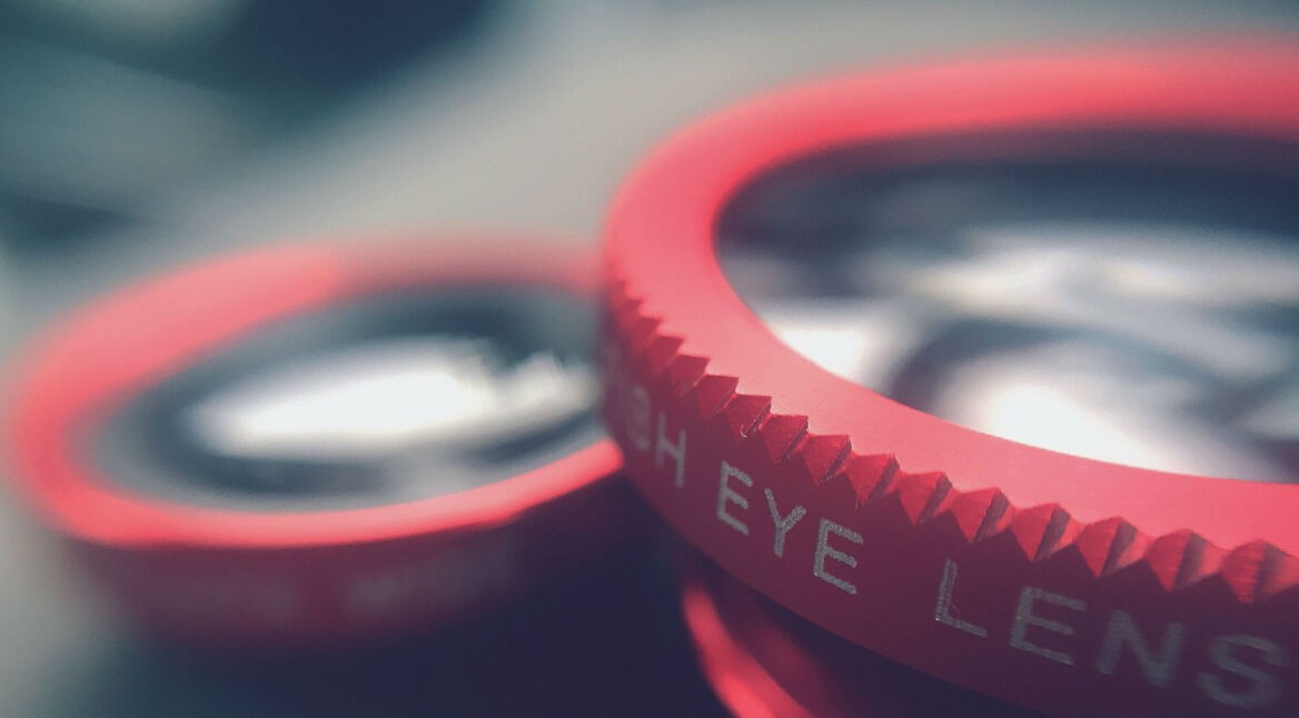 iPhone mit verschiedenen Zusatzlinsen und Halterung