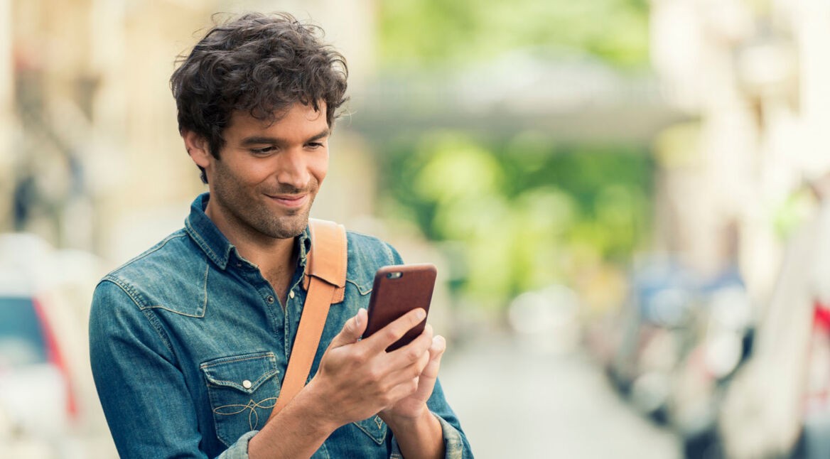 Mann liest Facebook-Nachrichten auf seinem Smartphone