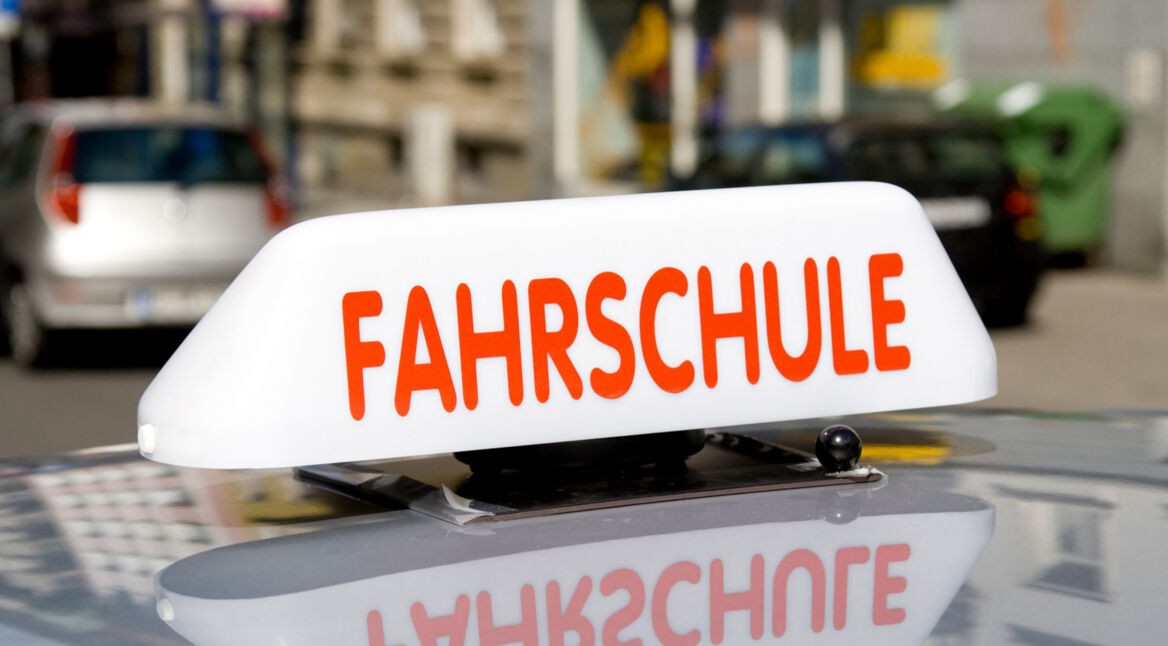 Fahrschulauto mit Schild auf dem Dach
