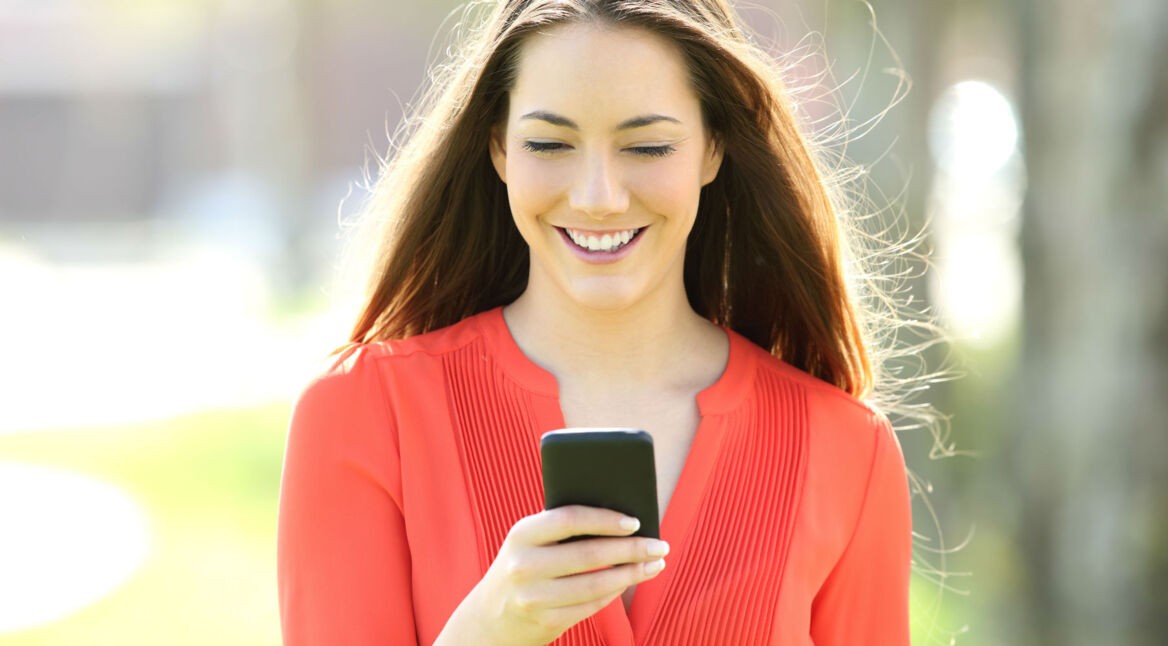 Frau mit roter Bluse und Smartphone