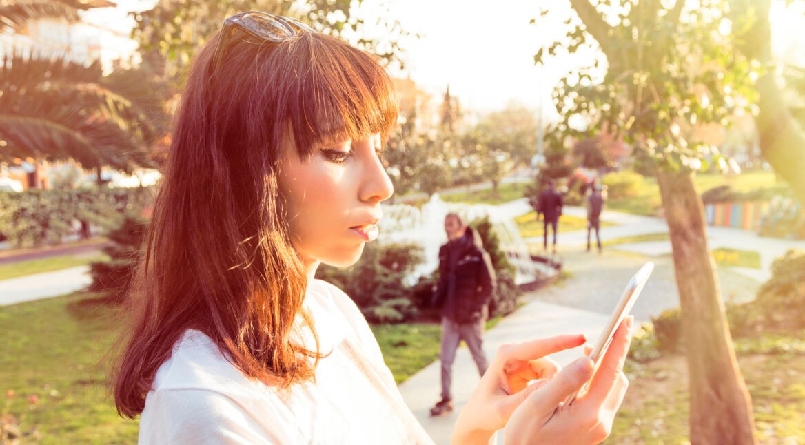 Frau mit Smartphone schaut sich etwas an