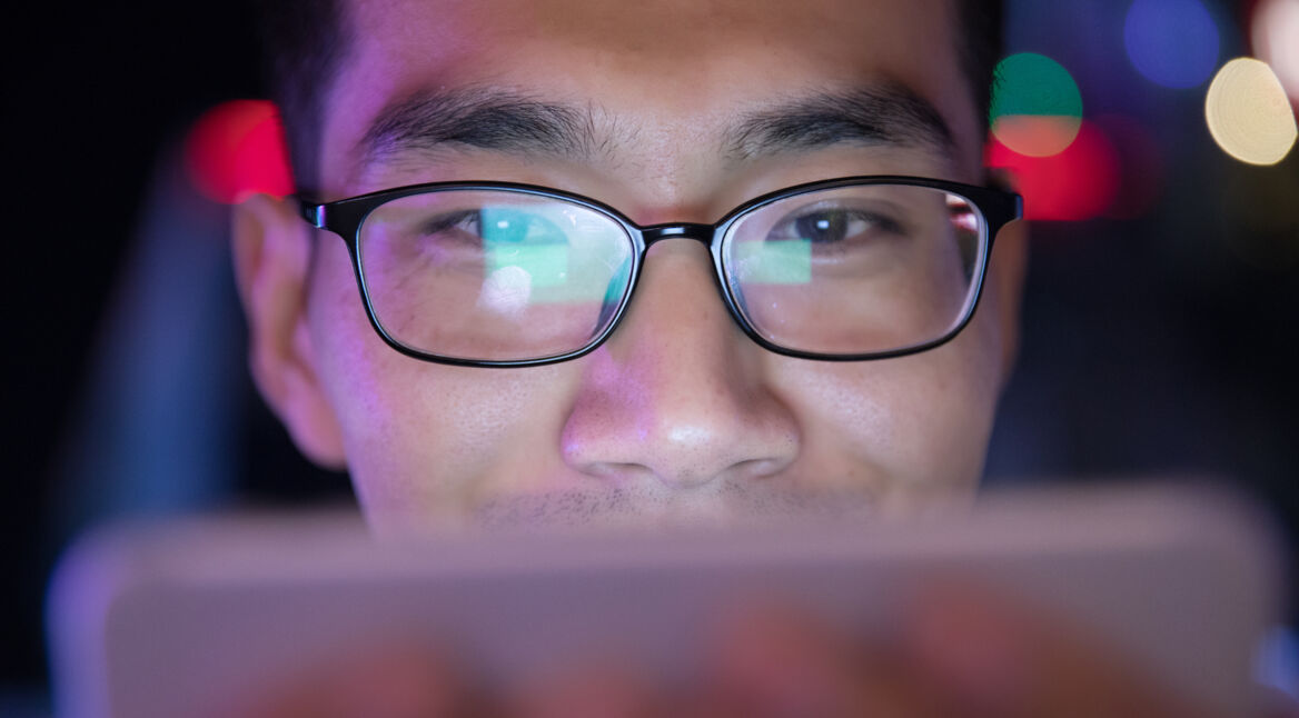 close-up man using mobile phone at night