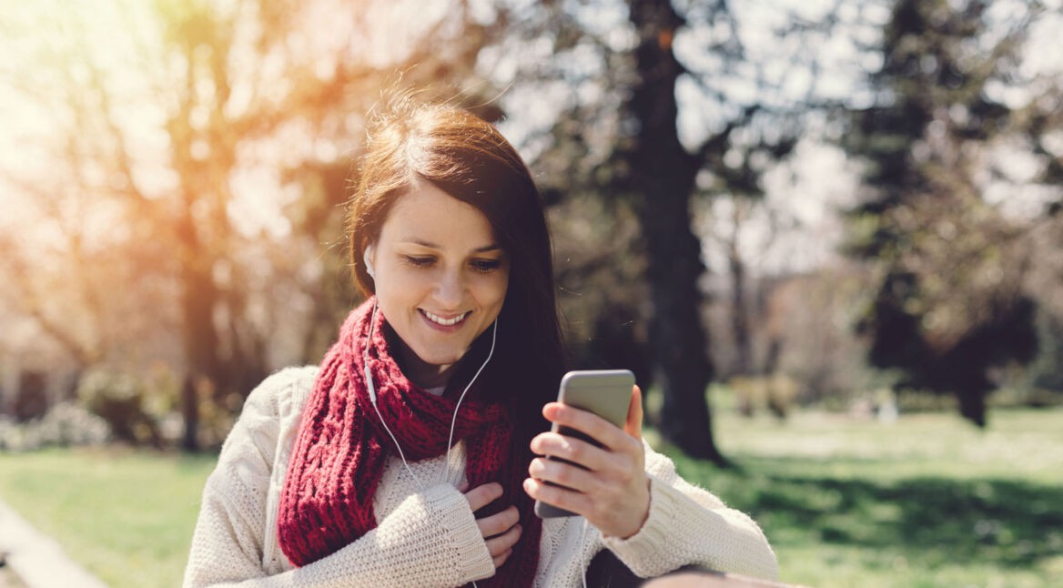 Mädchen auf einer Bank mit Smartphone