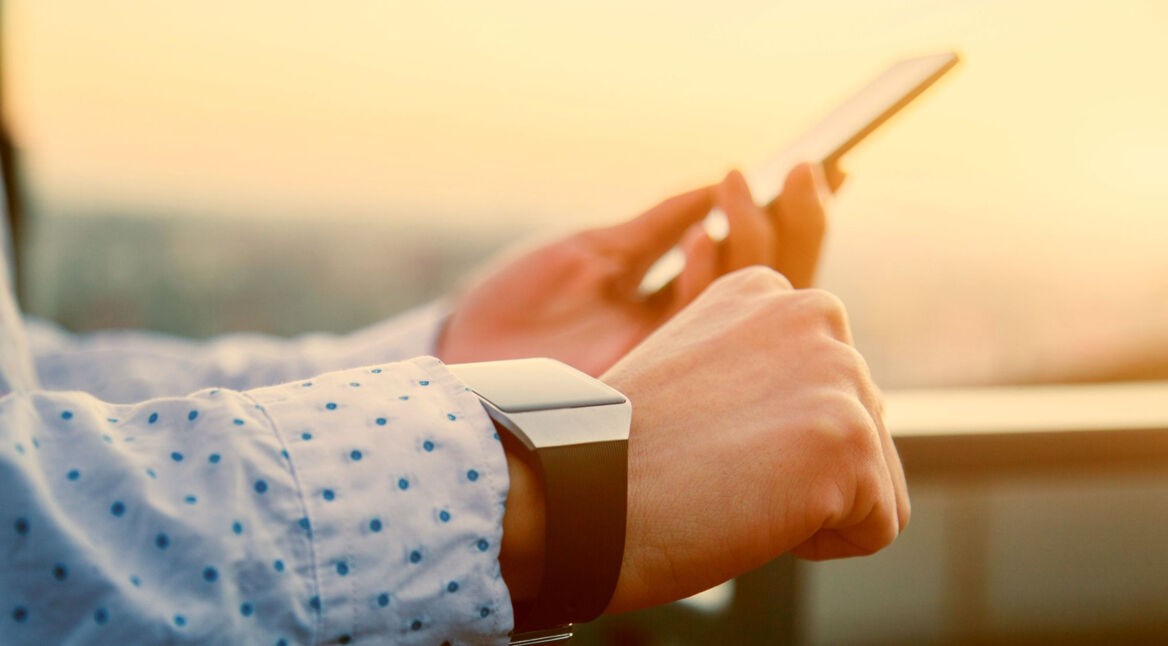 Mann mit Smart Watch und iPhone