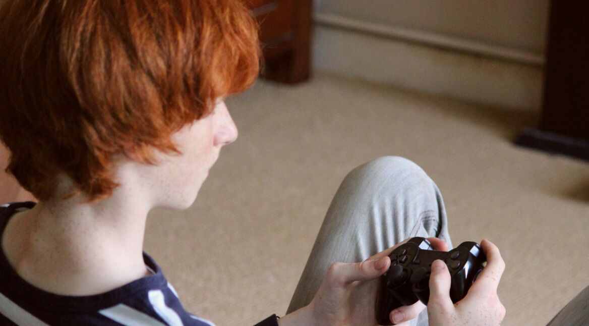 Teenager mit einem Playstation-Controller