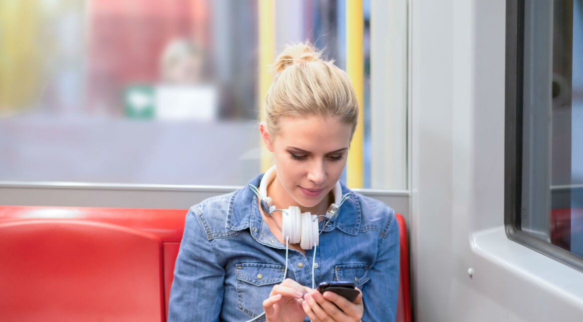 Frau mit Smartphone in der Bahn