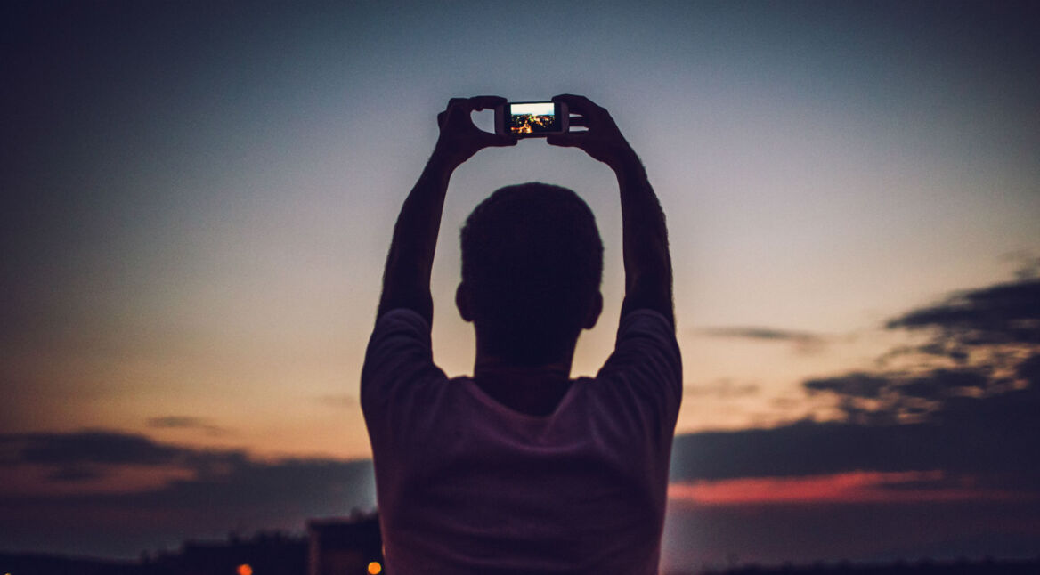 Mann nimmt ein Foto bei Dämmerung auf