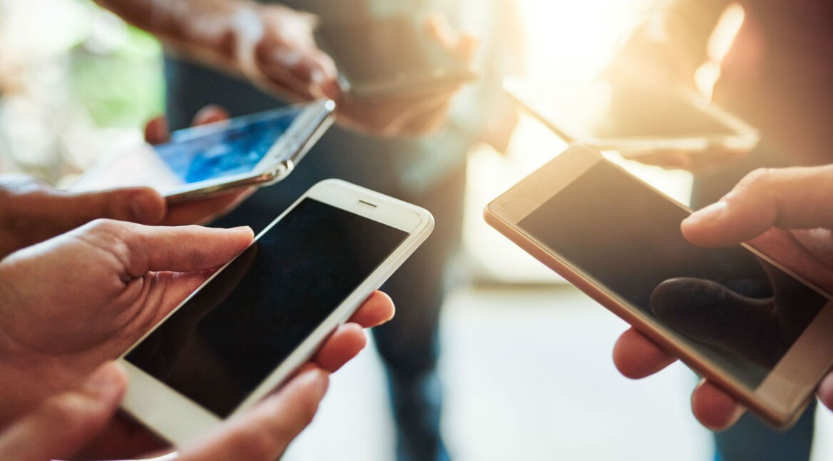 Eine Gruppe hält Smartphones in der Hand.