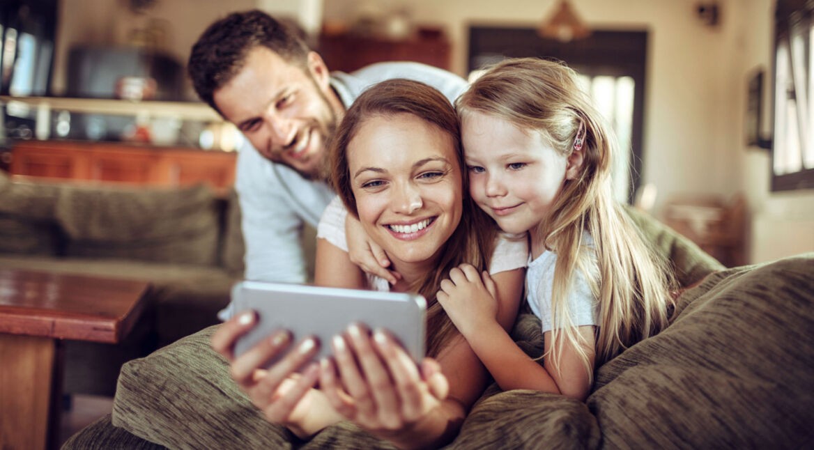 Familie schaut aufs Smartphone.