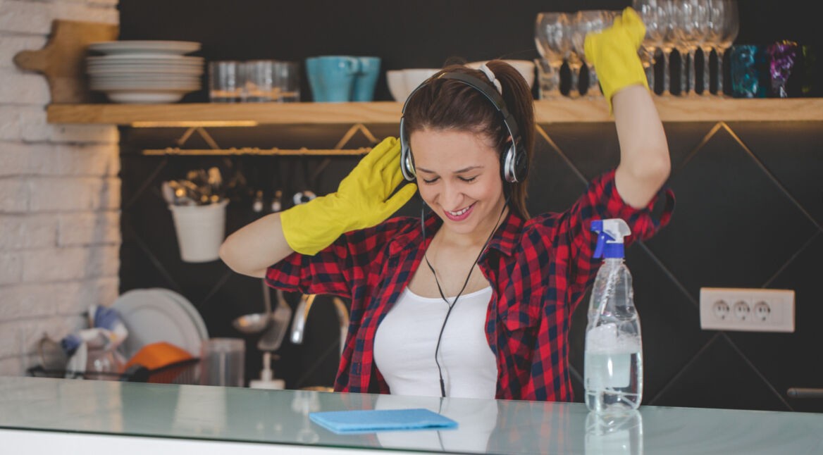 Frau mit Kopfhörern beim Putzen
