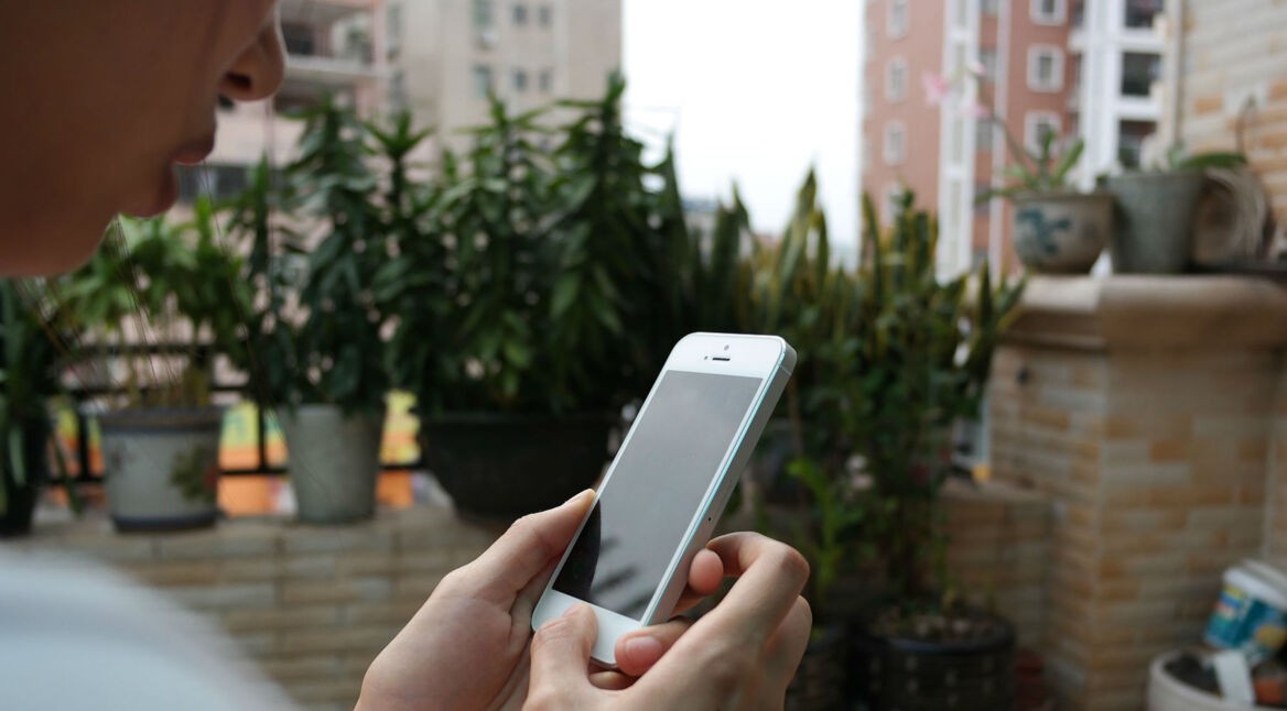 Mensch hält iPhone 5s in den Händen.