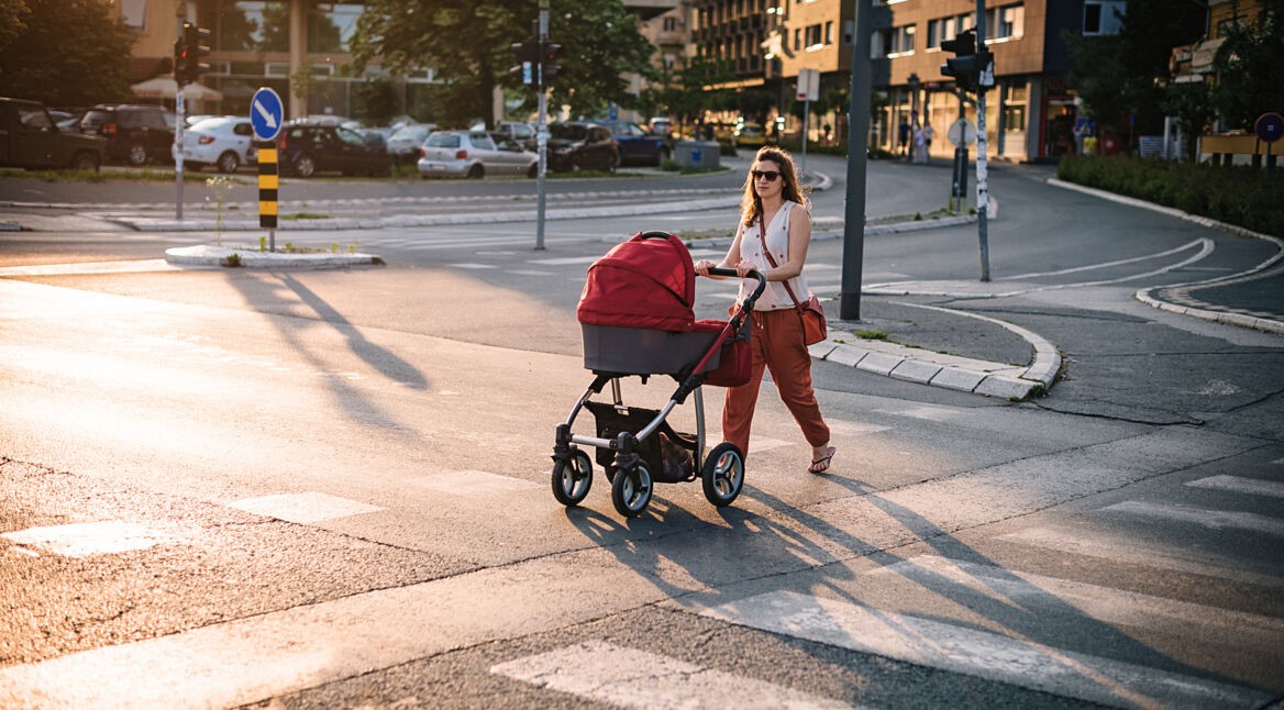 Young mother walking across the pedestrian crosswalk