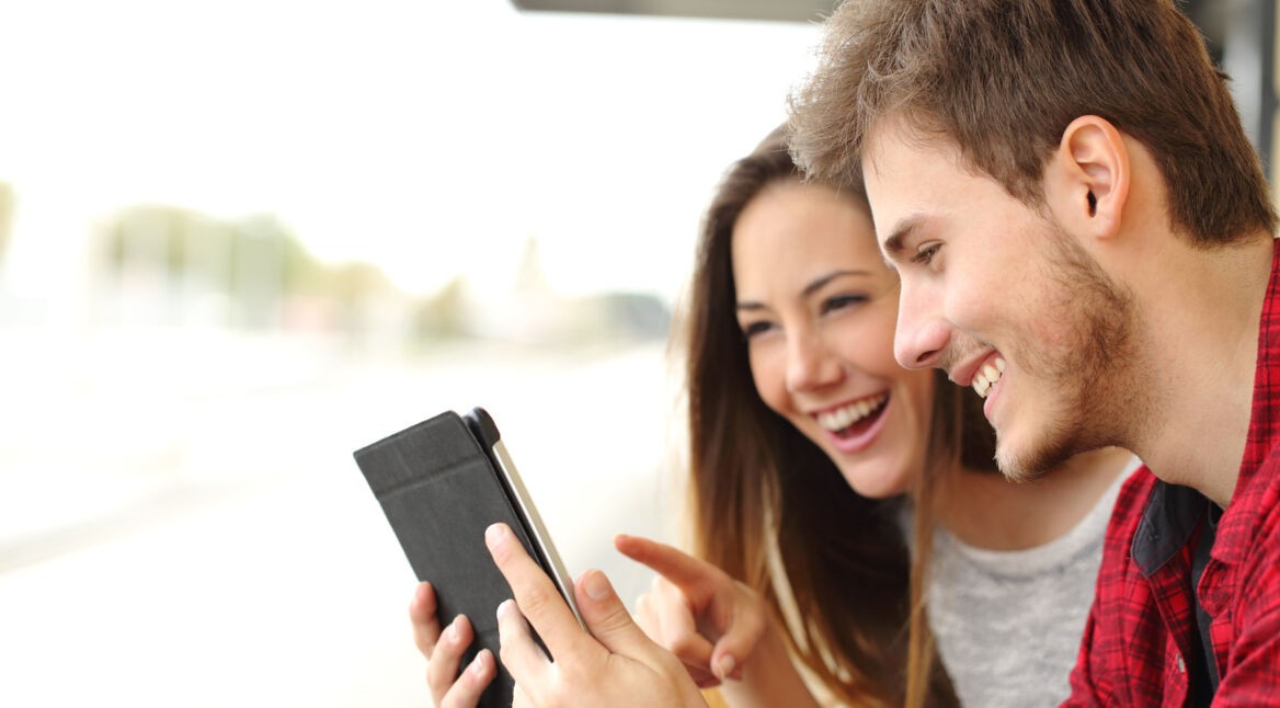 Junges Paar spielt draussen auf dem iPad