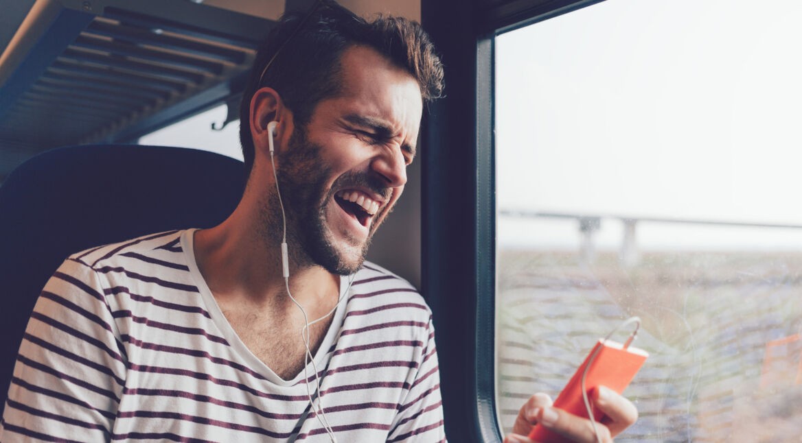 Mann singt im Zug in sein Handy