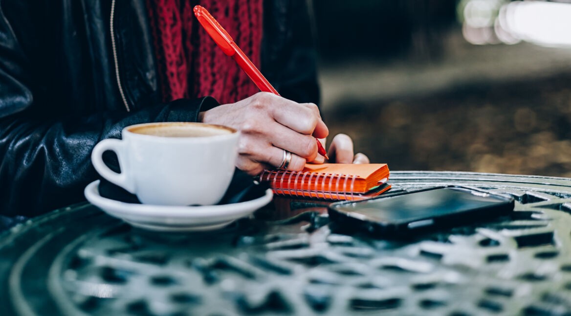 Mit Notizblock und Smartphone arbeiten