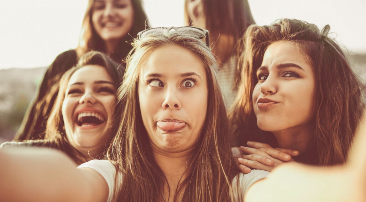 Frau macht ein lustiges Selfie mit Freunden.