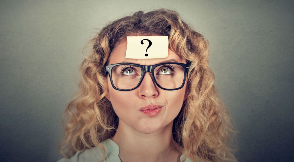 Verwirrter Frau klebt ein Fragezeichen auf der Stirn.