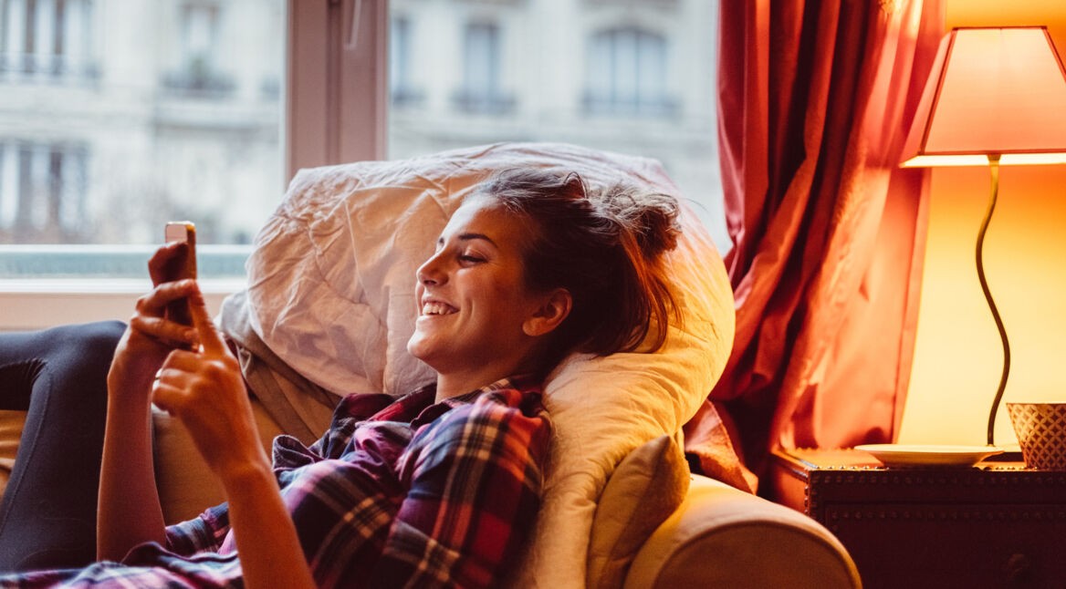 Frau steuert ihre Leselampe via iPhone