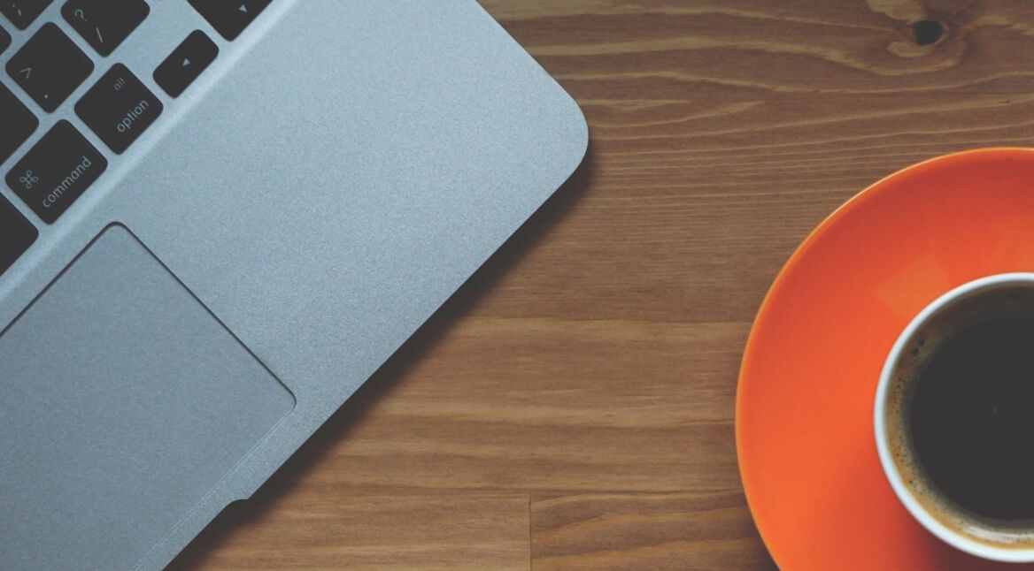 Macbook mit einer Kaffeetasse