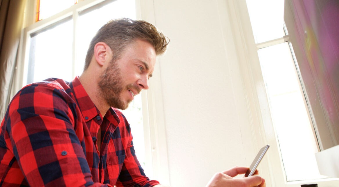 Mann im roten Hemd mit iPhone