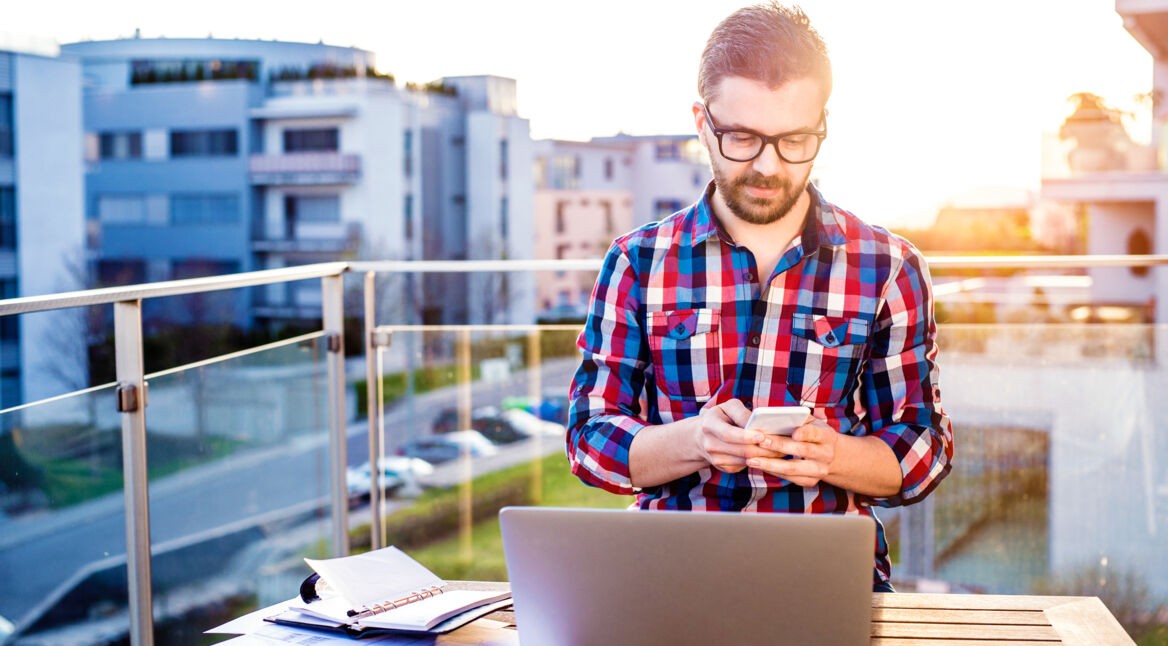 Mann schreibt auf seinem Smartphone