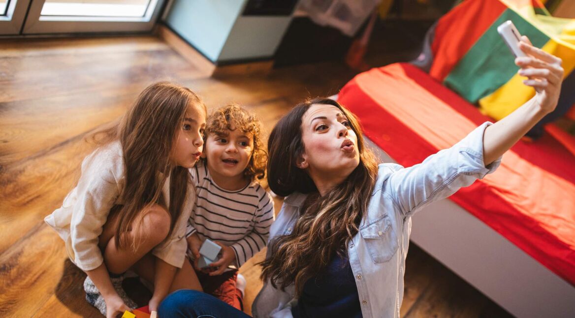 Young mother taking a selfie with her son and daughter
