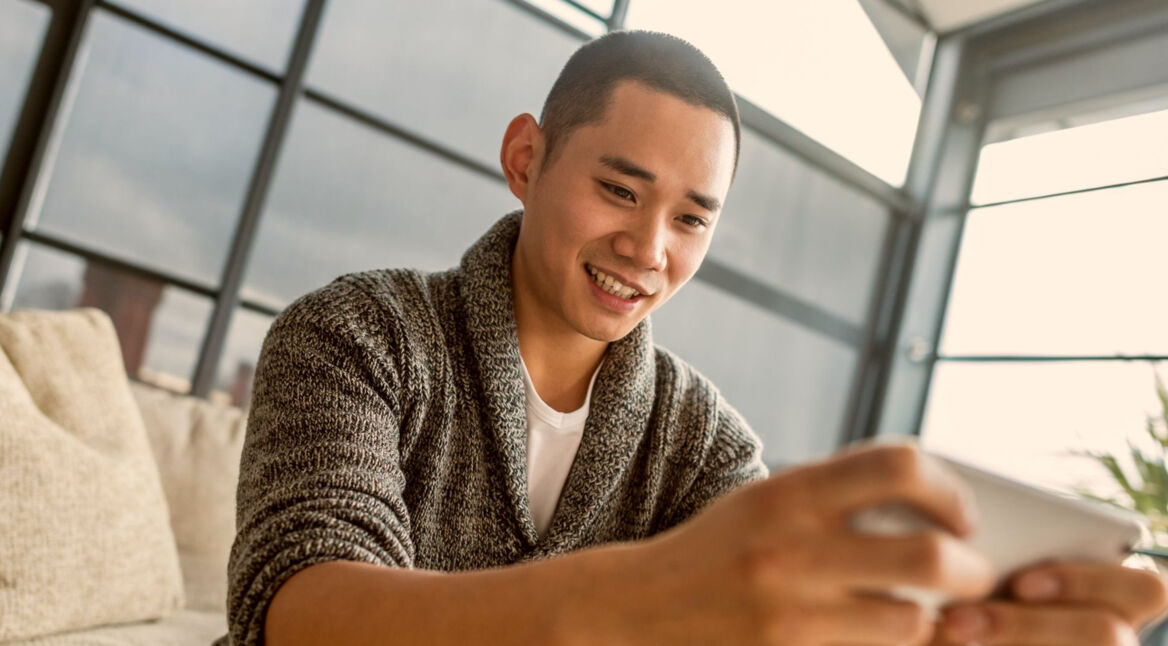 Mann spielt auf dem Smartphone