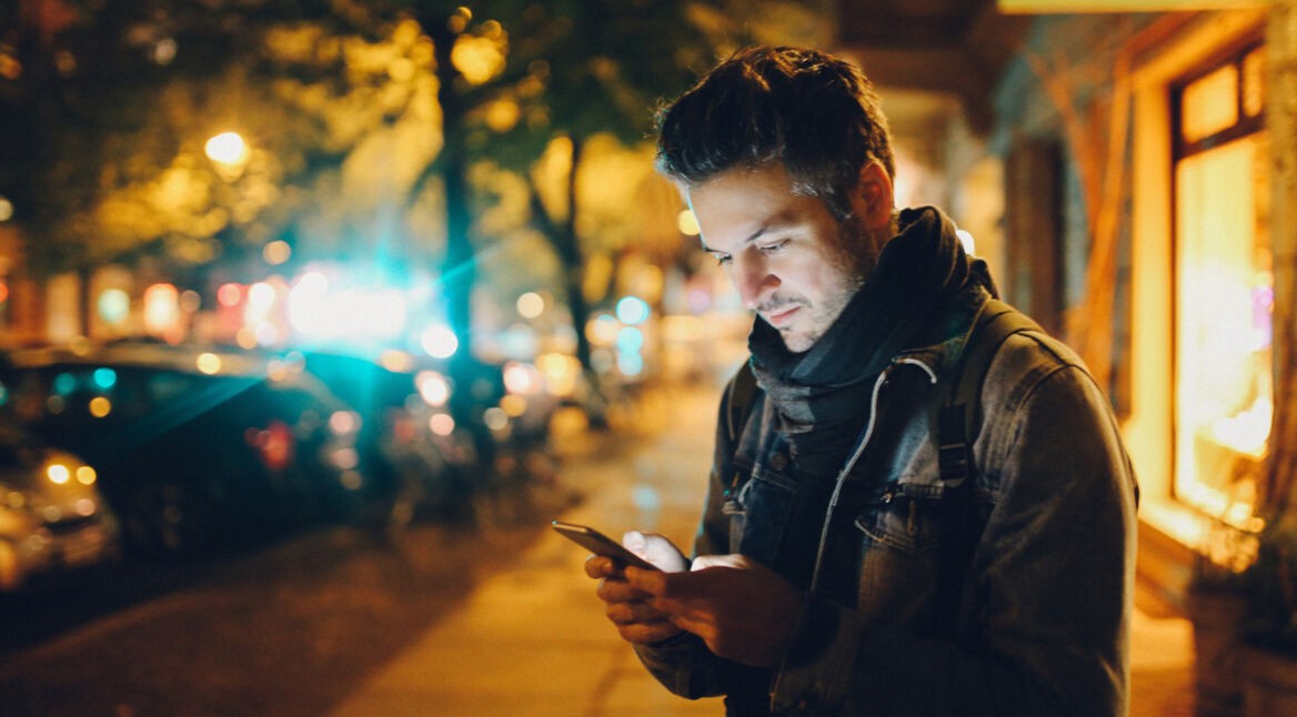 Mann schaut auf sein Smartphone-Display