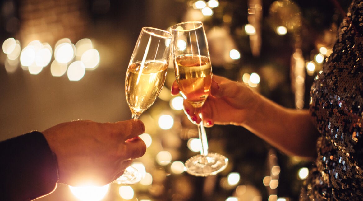 Zwei Personen stoßen mit Champagner an