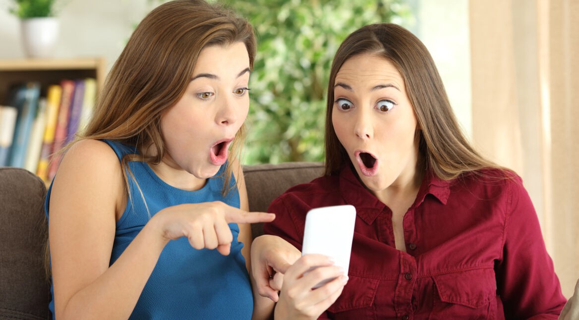 Zwei Frauen schauen begeistert auf ihr Smartphone