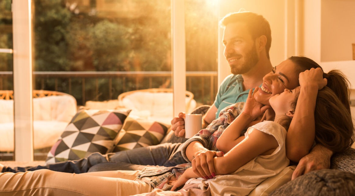 Glückliche Familie auf dem Sofa im smarten Zuhause