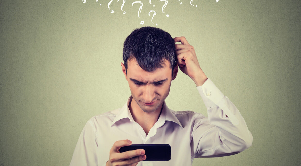 Ein Mann rätselt über sein Smartphone