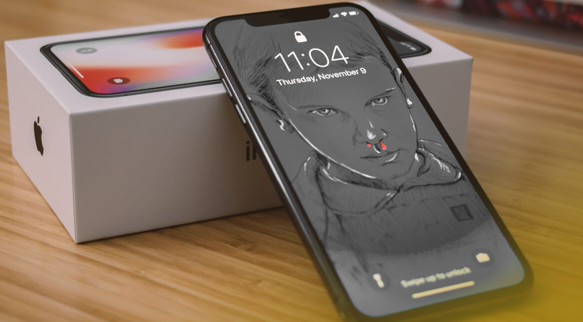 iPhone X mit Eleven von Stranger Things auf dem Bildschirm als Hintergrund.