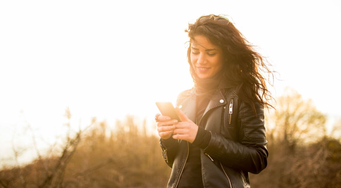 Junge Frau textet am Smartphone.