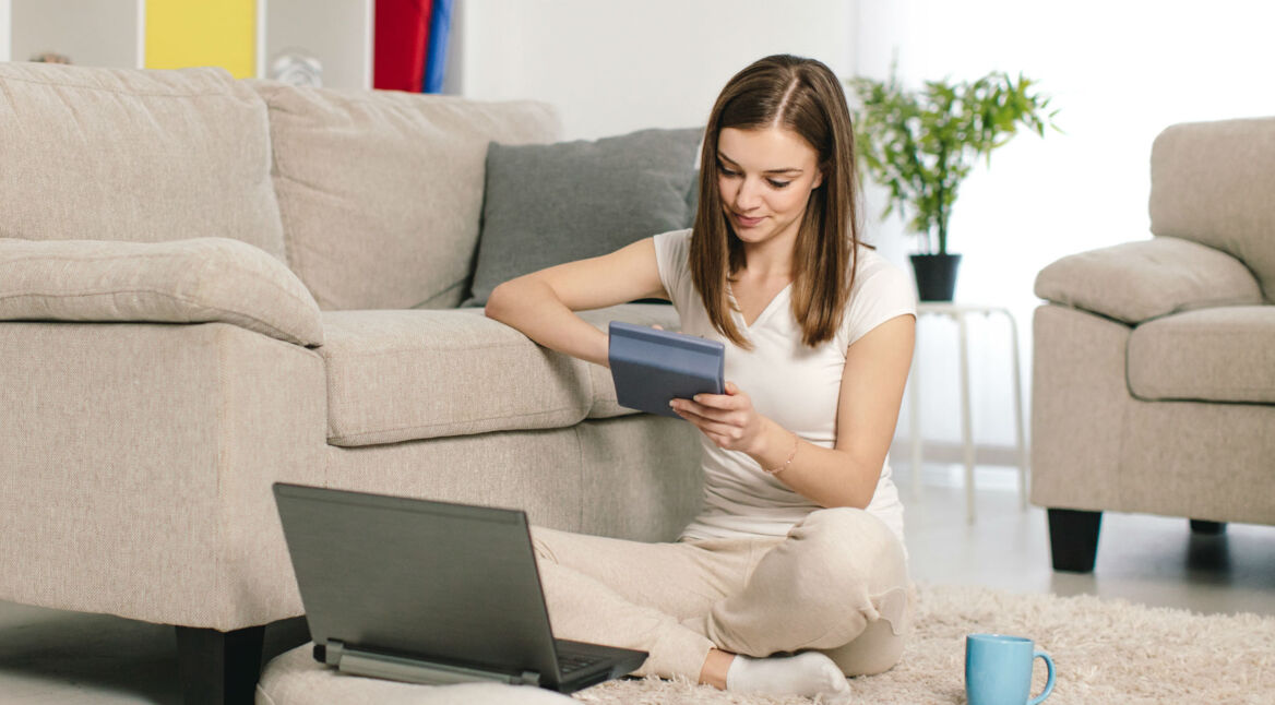 Junge Frau rechnet am Taschenrechner.