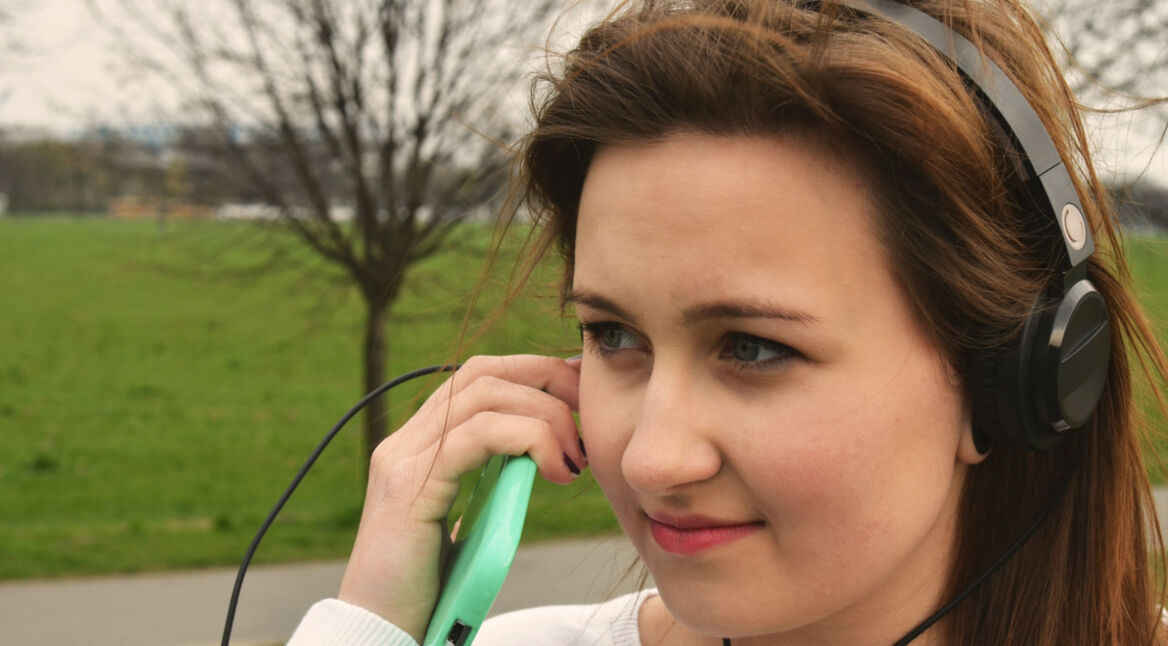 Junge Frau hört Musik mit dem Smartphone.