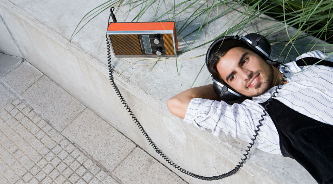 Mann hört Radio über Kopfhörer.