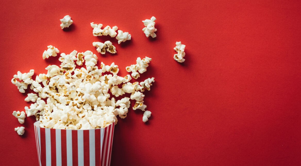 Popcorn liegt auf rotem Hintergrund.