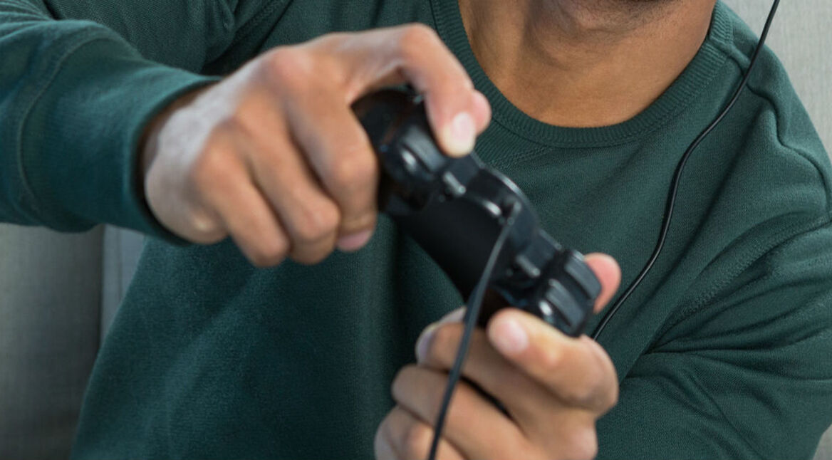 Junger Mann spielt ein Game mit dem PS4-Controller.