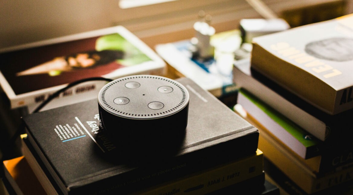 Amazon Echo Dot liegt auf einem Stapel Bücher.