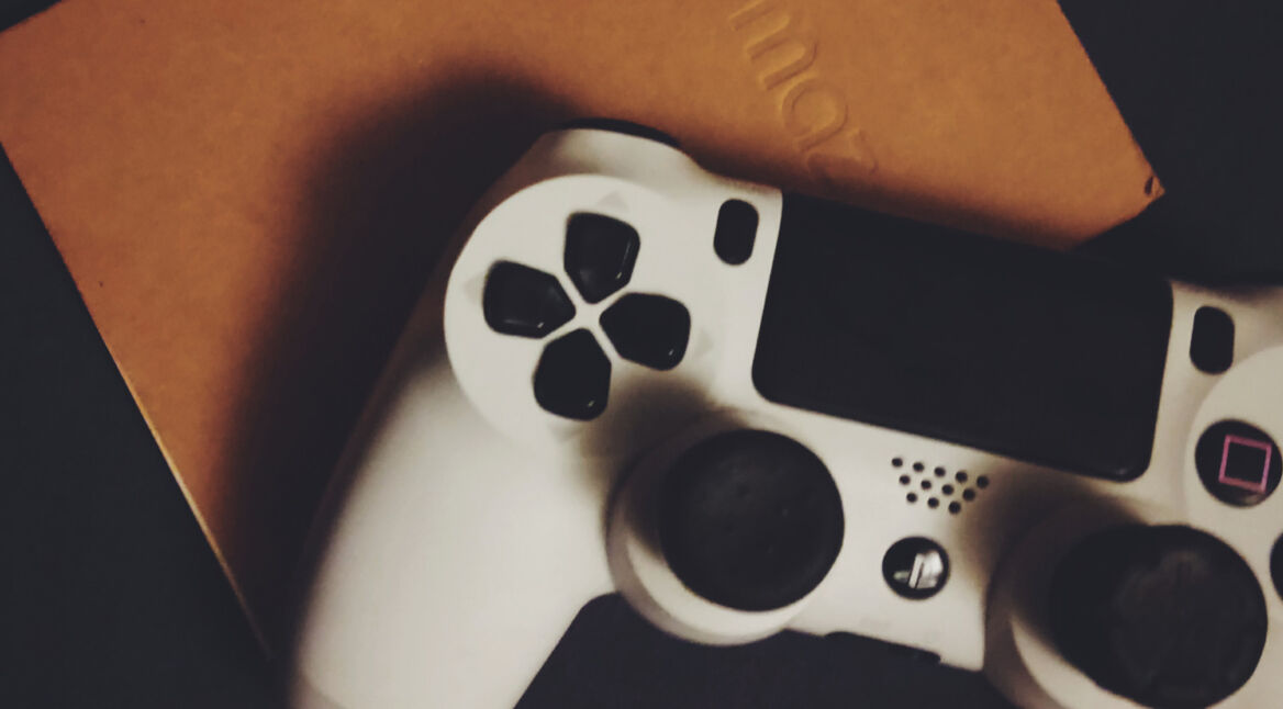 PS4-Controller in Weiß und ein Notizbuch