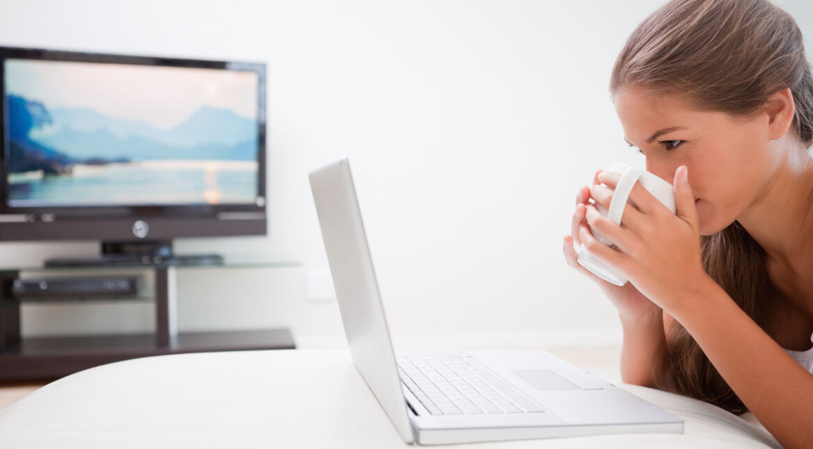Eine Frau streamt ihren Laptop-Bildschirm auf einen Fernseher
