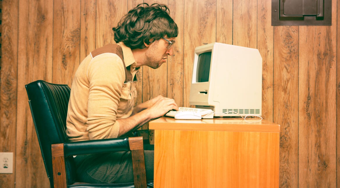 Funny Nerdy Man Looking Intensely at Vintage Computer