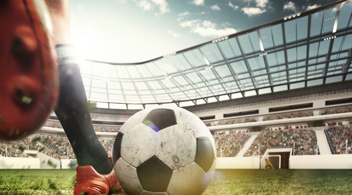 Legs of soccer player kicking the ball