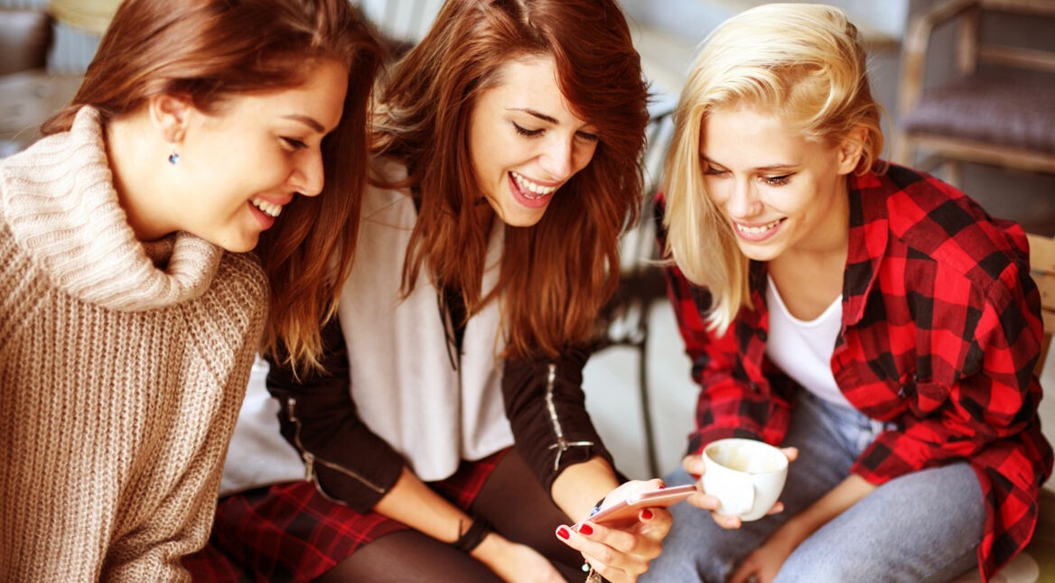 Gruppe von drei Frauen mit Smartphone