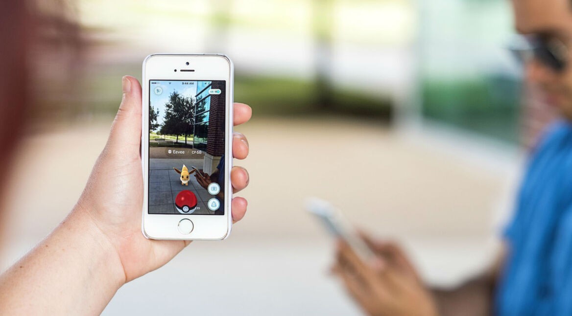 Jungs spielen Pokémon Go auf dem iPhone und fangen Pokémon wie Evoli.