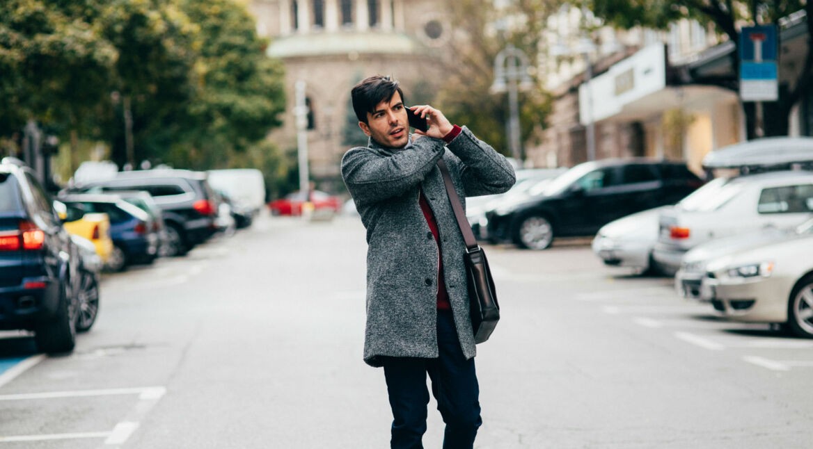 Junger Mann telefoniert dank SIM-Karte in seinem Smartphone.